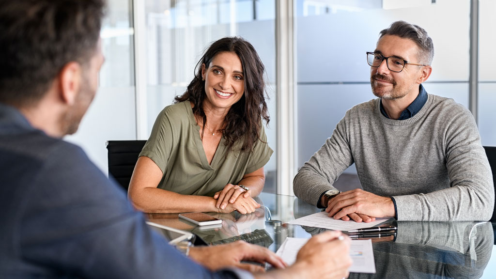 Conseiller expliquant un dossier de financement rénovation énergétique à un couple